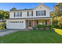 Charming two-story home with a manicured lawn and brick accents, offering curb appeal and a welcoming entrance at 118 Brandi Dr, Rolesville, NC 27571