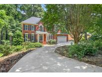 Charming brick home with mature trees and a well-manicured lawn, providing a welcoming curb appeal at 123 W Camden Forest Dr, Cary, NC 27518