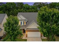 Charming two-story home with brick accents, white siding, manicured landscaping, and an attached two-car garage at 213 Florence Dr, Clayton, NC 27527