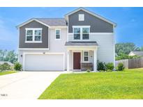 Charming two-story home features a well-maintained front yard and attached garage for modern suburban living at 221 Hallow Oak St, Spring Lake, NC 28390
