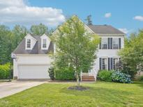 Charming two-story home with a well-manicured lawn, a two car garage, and beautiful landscaping at 2317 Colony Woods Dr, Apex, NC 27523