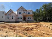 New two-story home in construction phase, revealing its framing and initial structure under a clear blue sky at 253 Inspiration Way, Fuquay Varina, NC 27526