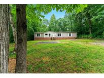 Charming single-story home with a well-maintained lawn, surrounded by lush greenery, and a traditional facade at 2832 Ladale Ln, Mebane, NC 27302