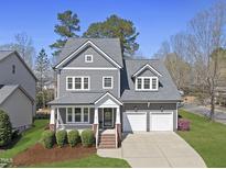 Charming two-story home featuring a two-car garage, manicured lawn, and a welcoming front porch at 300 Redhill Rd, Holly Springs, NC 27540