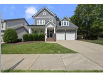 Charming two-story home with a two-car garage and well-manicured front lawn and landscaping at 300 Redhill Rd, Holly Springs, NC 27540