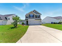 Charming two-story home with a well-manicured lawn and a spacious driveway on a sunny day at 350 Pillow Ln, Burlington, NC 27217