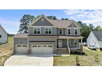 Charming two-story home with a three car garage, beautiful stone accents, and well-manicured lawn at 351 Lowery Ln, Benson, NC 27504