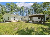 Backyard with a large lawn and a gazebo with outdoor furniture at 418 S West St, Cary, NC 27511