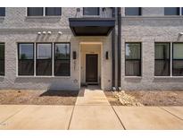 Modern townhome front door with a black awning and light brick facade at 421 Wait Ave # 100, Wake Forest, NC 27587