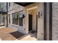 Modern townhome featuring a brick facade, covered entrance, and visible unit number at 421 Wait Ave # 100, Wake Forest, NC 27587