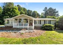 Charming ranch home with a welcoming front porch and lush, mature landscaping at 4701 Governor Hunt St, Efland, NC 27243