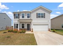 Charming two-story home features a well-maintained front yard and attached two-car garage at 637 Marrian Dr, Clayton, NC 27520