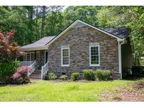 Charming stone facade and well-maintained lawn create great curb appeal at 856 Williams White Rd, Zebulon, NC 27597