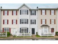 Traditional townhome featuring a white picket fence and well-maintained facade at 8610 Neuse Landing Ln # 103, Raleigh, NC 27616