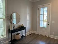 Bright entryway with a decorative table, mirror, and woven basket, creating a welcoming atmosphere at 1006 Starkville St, Durham, NC 27713