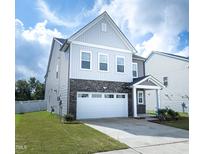 Charming two-story home features a two-car garage, beautiful stone accents and manicured lawn at 1016 Matterhorn Dr, Fuquay Varina, NC 27526