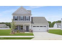 Charming two-story home with gray siding, a two-car garage, and a well-manicured lawn at 142 Benson Village Dr # 82, Benson, NC 27504