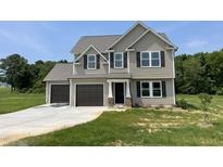 Charming two-story home featuring a two-car garage, a manicured lawn and classic siding at 159 Coharie Dr, Lillington, NC 27546