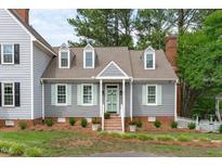 Charming home featuring gray siding, a brick foundation, and light green shutters at 1813 Carrington Dr, Raleigh, NC 27615