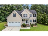 Inviting two-story home with a manicured lawn, black shutters, and a two-car attached garage at 185 Keller Dr, Clayton, NC 27520
