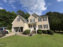Charming two-story home with black shutters, manicured lawn, and attached garage at 185 Keller Dr, Clayton, NC 27520