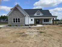 Charming new construction home with stone accents, a covered porch and manicured yard at 188 Banner Elk Rd, Benson, NC 27504