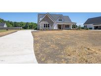Charming exterior elevation featuring stone accents, a welcoming porch, and a spacious front yard at 188 Banner Elk Rd, Benson, NC 27504