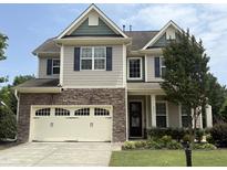 Charming two-story home featuring a stone facade, two-car garage, and well-manicured lawn at 2361 Rainy Lake St, Wake Forest, NC 27587