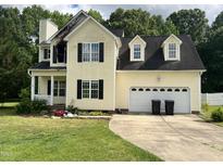 Two story home with attached two car garage, front porch, and fire damage at 2377 Vinson Rd, Clayton, NC 27527