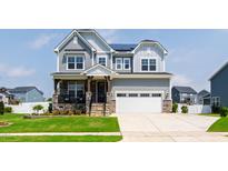 Charming two-story home with stone accents, inviting porch, and well-manicured lawn at 272 High Woods Rdg, Chapel Hill, NC 27517