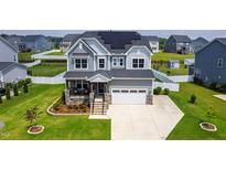 Beautiful two-story home with solar panels, manicured lawn, and a welcoming stone porch at 272 High Woods Rdg, Chapel Hill, NC 27517