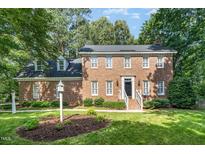 Stately brick two-story home featuring manicured lawn, mature trees, and classic architectural details at 4020 Gumleaf Dr, Apex, NC 27539