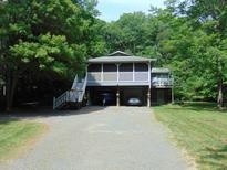 Two-story home featuring dual carports and a screened porch with a staircase entrance at 4144 Fairport Rd, Kittrell, NC 27544
