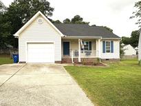 Charming single-story home featuring a front porch, attached garage, and well-maintained lawn at 5316 Tanglewood Pine Ln, Raleigh, NC 27610
