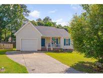 Charming single-story home featuring a well-maintained lawn, front porch, and a one-car garage at 5316 Tanglewood Pine Ln, Raleigh, NC 27610
