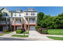 Charming townhome with a brick facade, private balcony, and well-manicured lawn at 717 Samuel Cary Dr, Cary, NC 27511