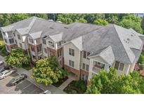 An aerial view of a multi-story condo building with brick and siding and private balconies at 735 Portstewart Dr, Cary, NC 27519