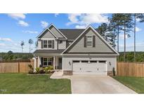 Charming two-story home with a well-manicured lawn and attached two-car garage at 784 Cypress Rd, Cameron, NC 28326