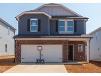 Charming two-story home featuring a brick-accented facade, attached two-car garage, and modern architectural details at 837 Ottawa Dr, Garner, NC 27529