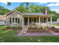 Charming one-story home featuring a welcoming front porch, neutral siding, and lush landscaping, set on a beautiful lot at 847 E Maple Ln, Fuquay Varina, NC 27526