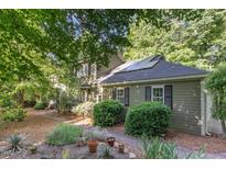 Charming home featuring solar panels, black shutters, and a beautifully landscaped front yard with lush greenery at 850 N Langdon, Pittsboro, NC 27312