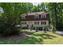Charming two-story home with a well-manicured lawn and mature trees providing shade at 1005 Temple St, Raleigh, NC 27609