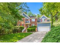 Charming two-story home with brick and siding, red shutters, and lush landscaping at 102 Winged Foot Ct, Mebane, NC 27302