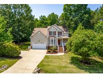 Inviting two-story home with red shutters, a well-manicured lawn and a two car garage at 1033 Cabin Hill Way, Garner, NC 27529