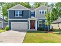 Charming two-story home with a well-manicured lawn, attached garage and inviting red front door at 128 Potomac River St, Garner, NC 27529