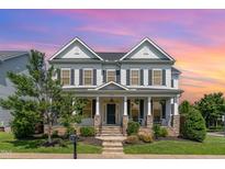 Charming two-story home with stone accents, inviting front porch, and manicured landscaping at 1304 Revolution Cir, Raleigh, NC 27603