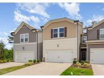 Charming townhome featuring neutral siding, a single-car garage, and well-manicured landscaping at 136 Ashlar Ct, Cary, NC 27519