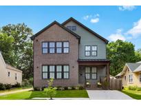 Charming two-story home with a brick and siding exterior, landscaped yard, and a welcoming front porch at 1405 Watts St, Durham, NC 27701