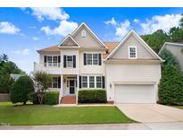 Charming two-story home with beautiful landscaping, a front porch, and an attached two-car garage at 1420 Lagerfeld Way, Wake Forest, NC 27587
