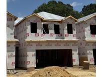 New construction shows unfinished exterior with wood framing and materials, offering a glimpse of a modern home in progress at 180 W Allen St, Four Oaks, NC 27524